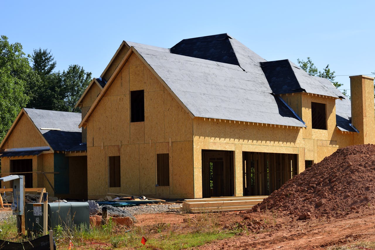 pexels photo 209266 A partially built wooden house under construction, showcasing its progress and design in daylight.